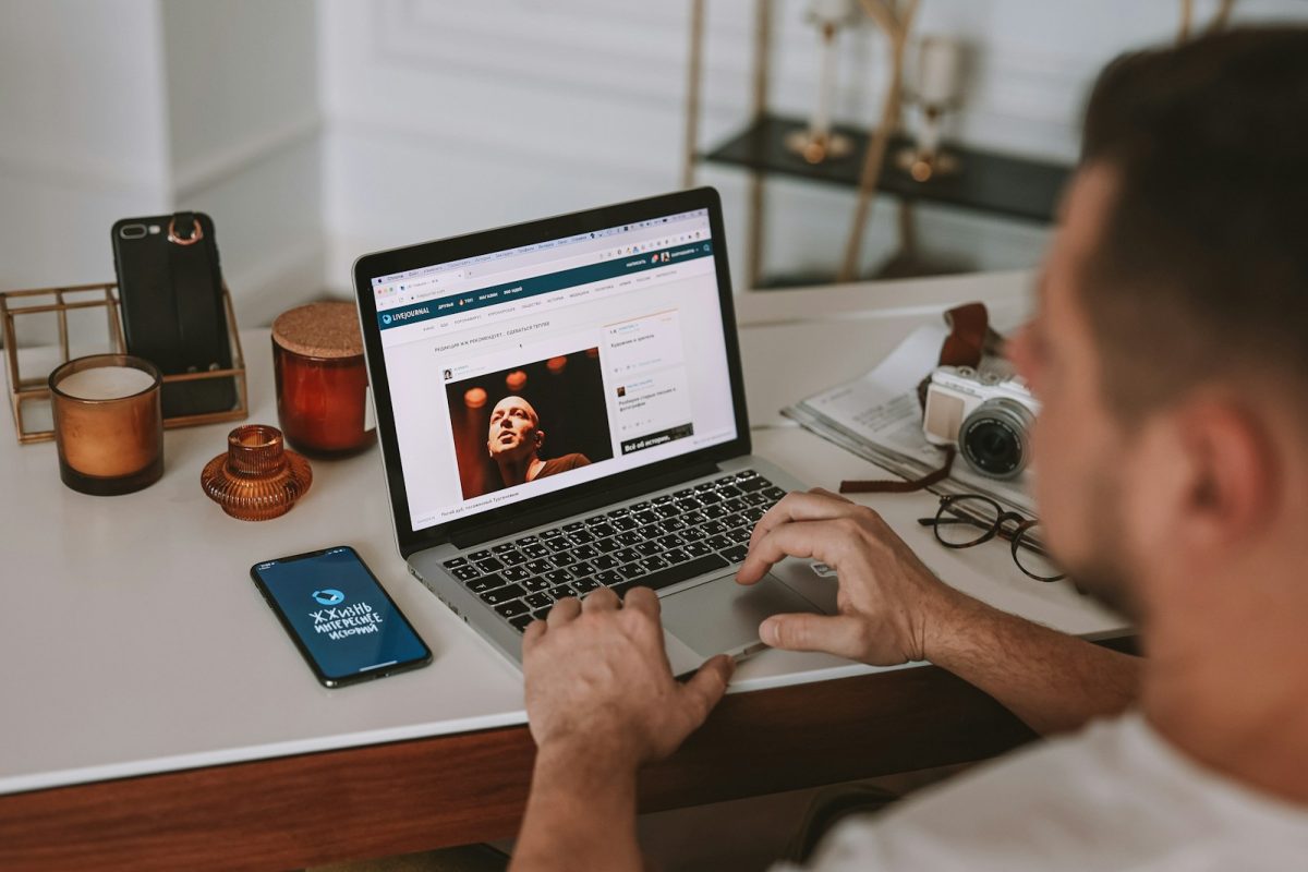 a man sitting at a desk using a laptop computer